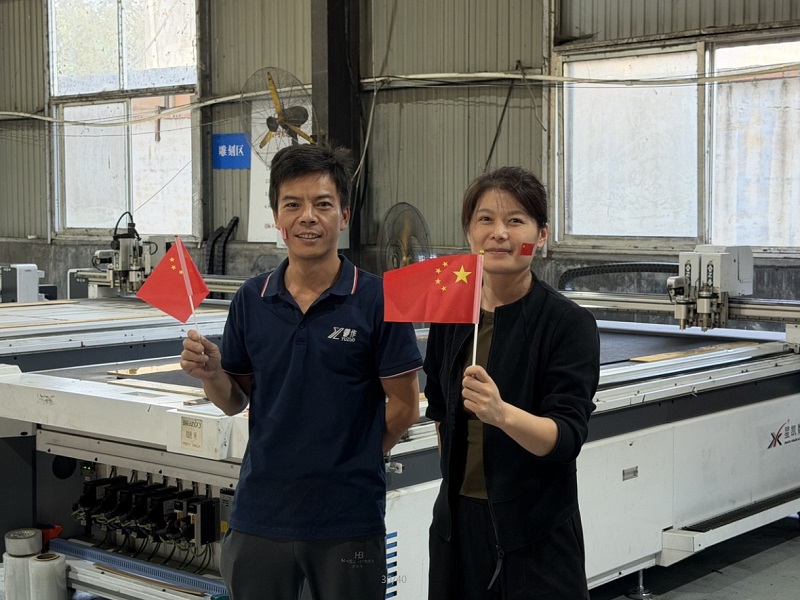 A National Day moment beside production equipment.